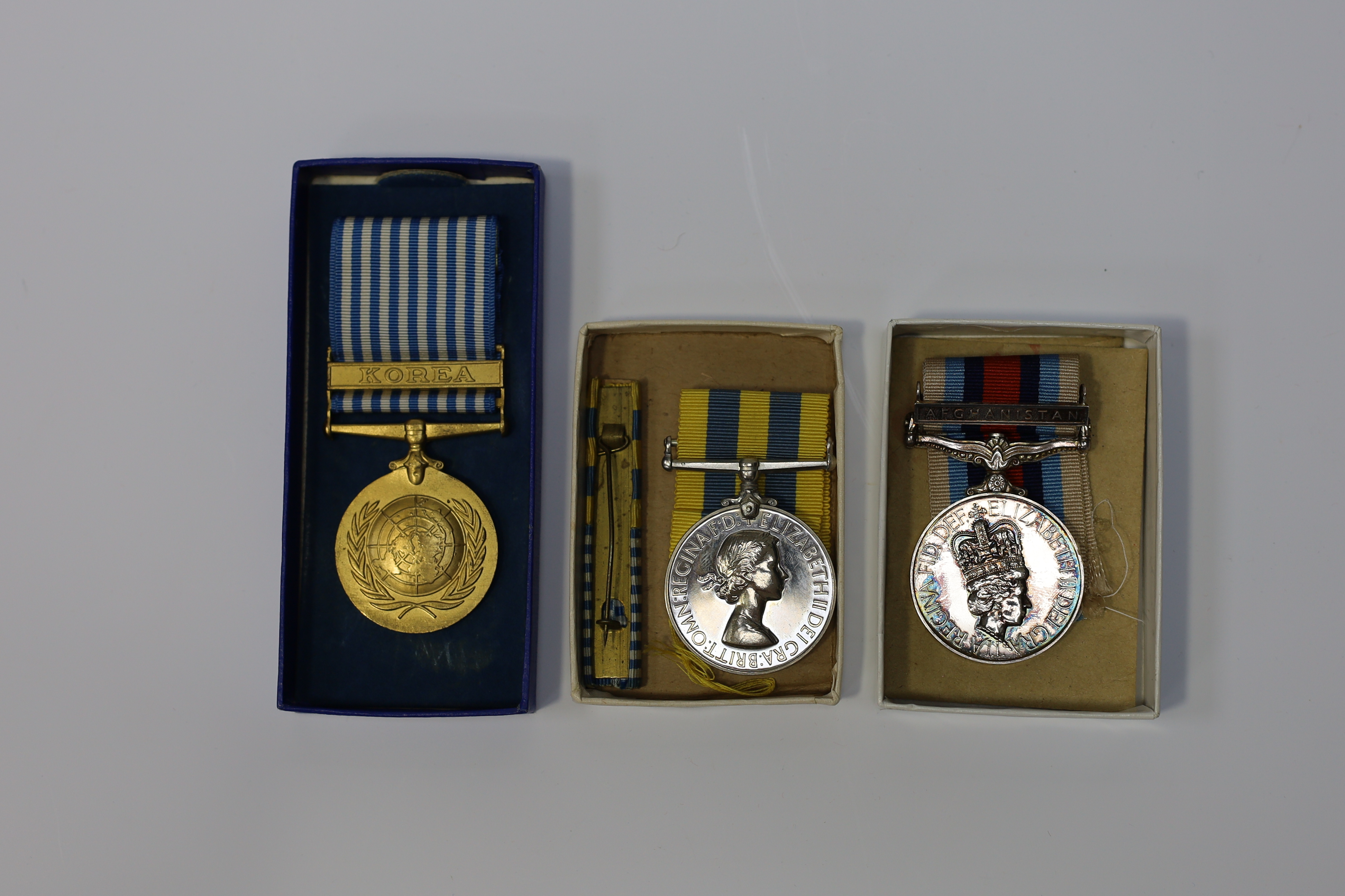 An ERII Operational Service Medal for Afghanistan awarded to Sgt. A.J. Pugsley RAMC (R), together with a Korea medal pair awarded to Sigmn. A.G. Lickman R.Sigs., all in separate issue boxes. Condition - fair to good